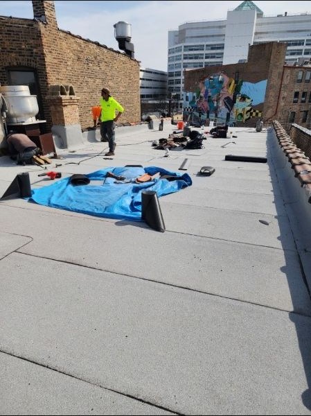 Commercial flat roofing work underway on a masonry building