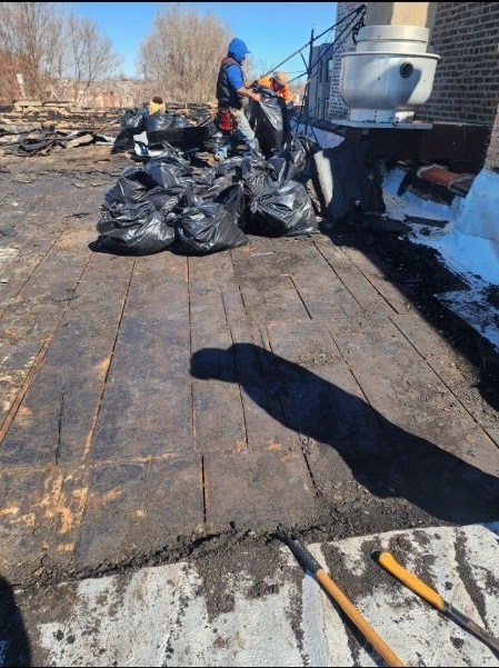 Roof tear-off in progress with old roofing removed down to the deck